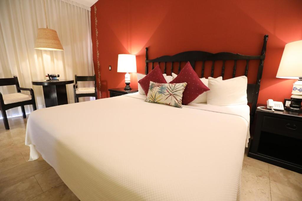 a bed room with a white bedspread and two lamps at Hotel Montetaxco in Taxco de Alarcón