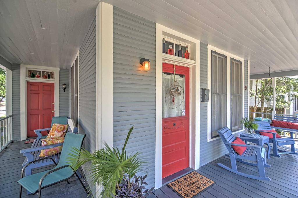 a porch with blue chairs and a red door at Charming Gulfport Getaway Only 3 Blocks to Beach! in Gulfport