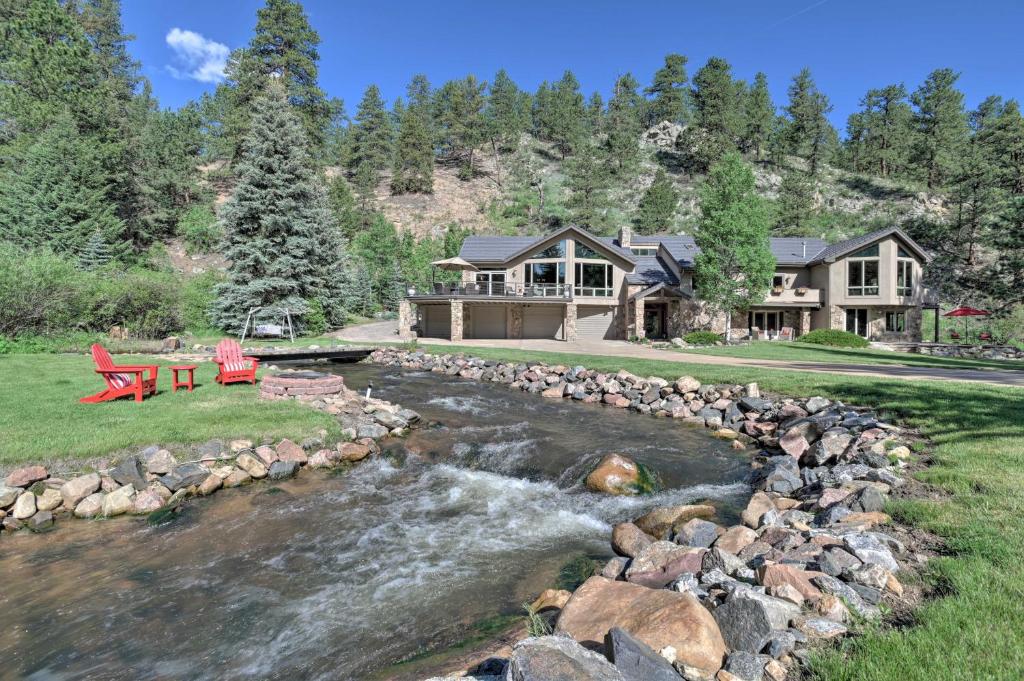 uma casa com um rio em frente em Stunning Evergreen Mountain Home on Private Stream em Evergreen