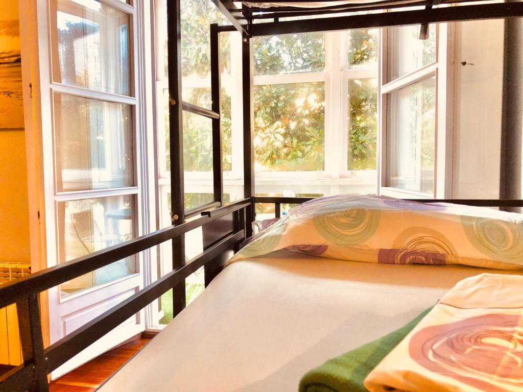 a bedroom with a bed with a large window at Hostel Santander in Santander