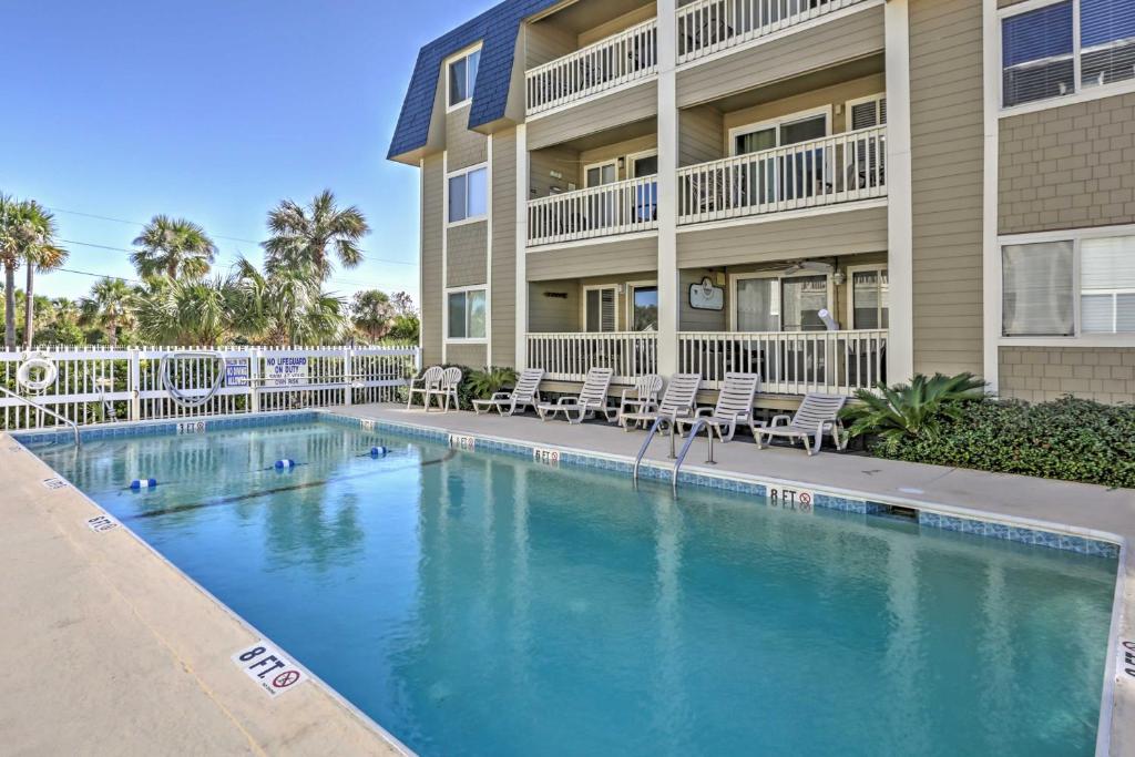 a swimming pool in front of a building at Isle of Palms Condo with Pool Access Walk to Beach! in Isle of Palms