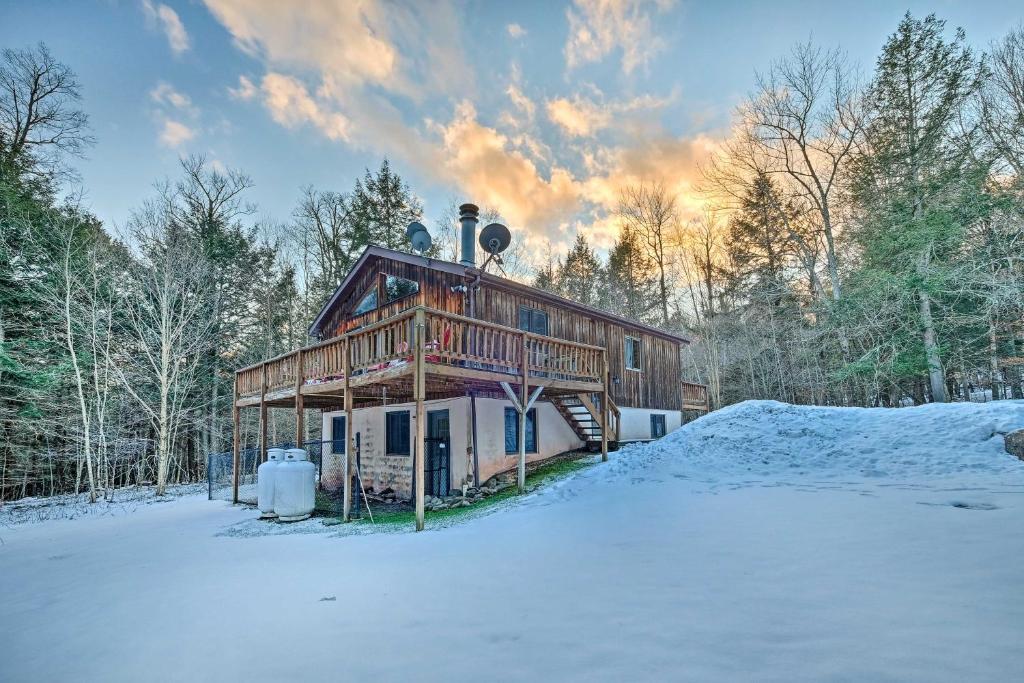 a log cabin in the snow with a snow covered yard at Jewett Cabin with Viewing Deck - 10 Mins to Skiing! in Jewett