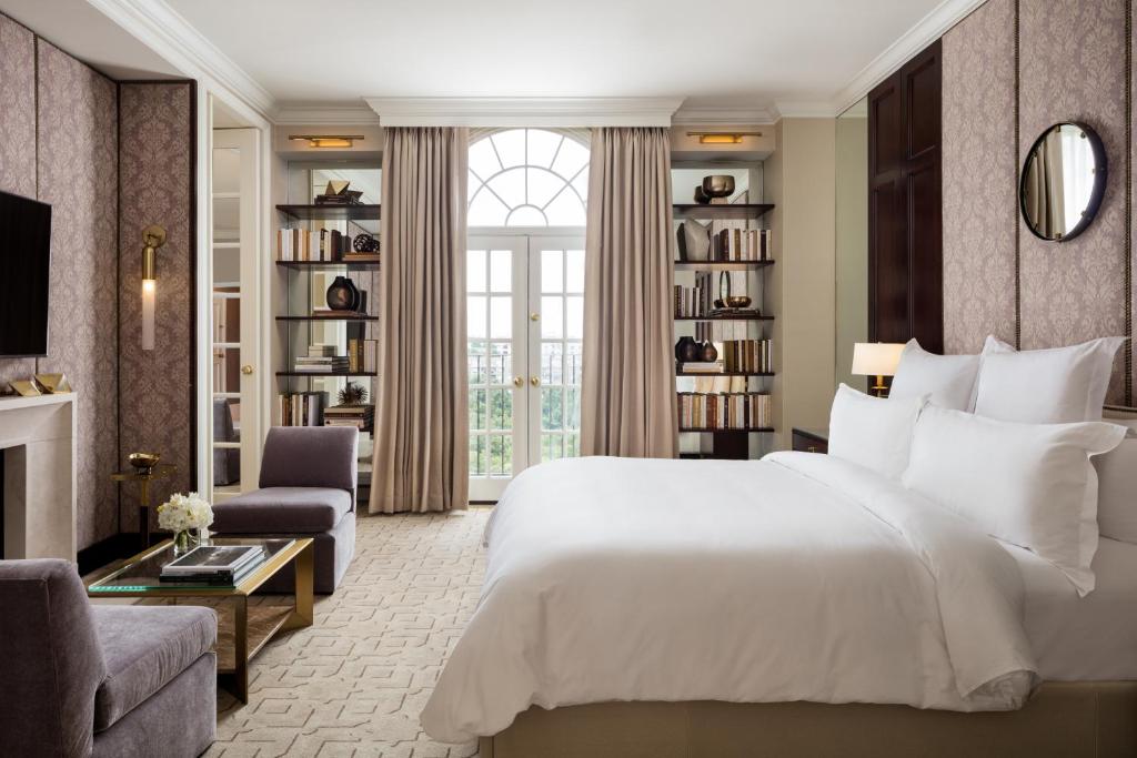 um quarto com uma grande cama branca e uma sala de estar em Rosewood Mansion on Turtle Creek em Dallas