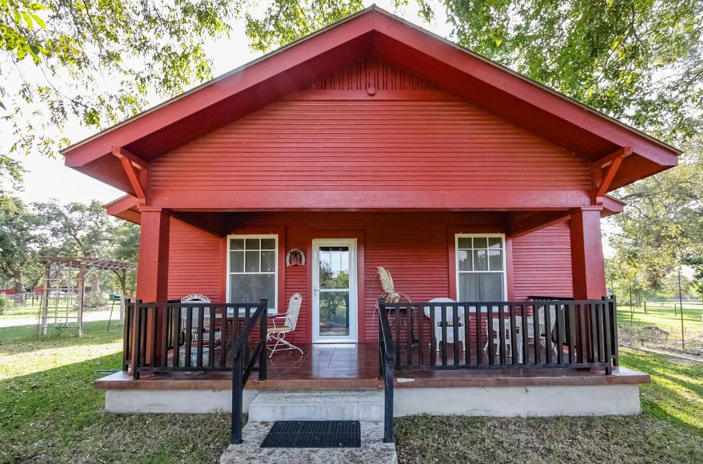 een rood huis met twee stoelen ervoor bij August Schmidt Fredericksburg Cottage with Hot Tub in Fredericksburg