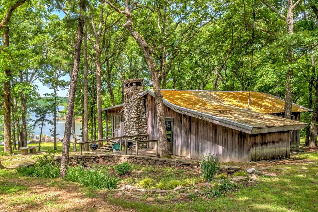 uma velha cabana na floresta com árvores em Waterfront New Concord Paradise on Kentucky Lake! em Faxon