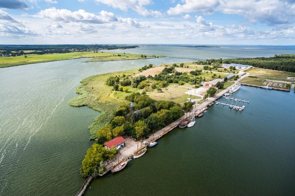 佩內明德的住宿－Halbinsel Resort Peenemünde，河流中岛屿的空中景观,有船