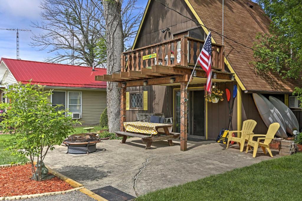 een huis met een terras met een bankje en een vlag bij Lakeview A-Frame Steps to Marina and Old Field Beach in Lakeview