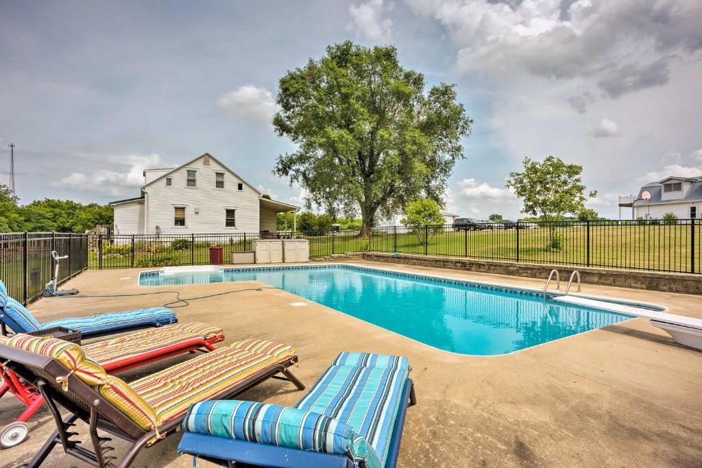 einen Pool mit zwei Liegestühlen und ein Haus in der Unterkunft Cozy Missouri Retreat with Pool, Pond and Fire Pit! in Berger