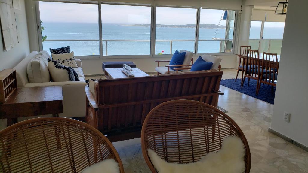 a living room with a couch and chairs and the ocean at Amazing Oceanfront unit on Mansa Beach in Punta del Este