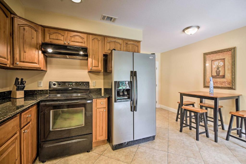 a kitchen with a stainless steel refrigerator and a table at Gulfport Condo with Private Balcony - Walk to Beach! in Gulfport