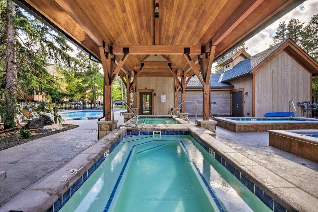 an outdoor pool with a wooden pergola and a house at SnowDogs Breck Condo with Fireplace Walk to Lifts in Breckenridge