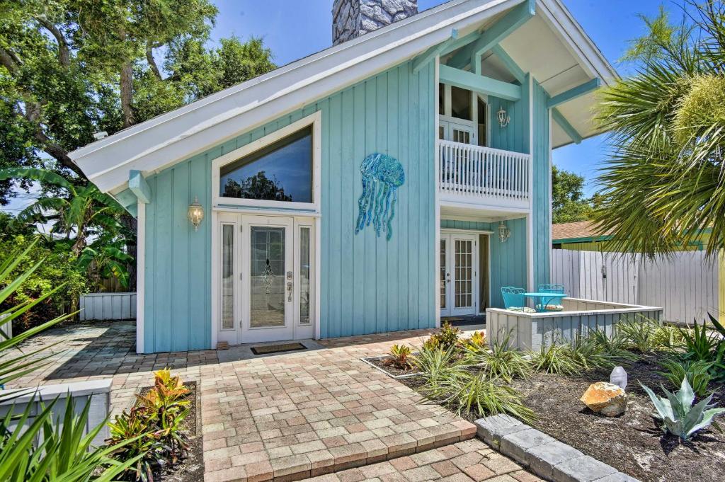 una casa azul con un patio frente a ella en Cape Canaveral Cottage with Pool - Walk to Beach!, en Cabo Cañaveral