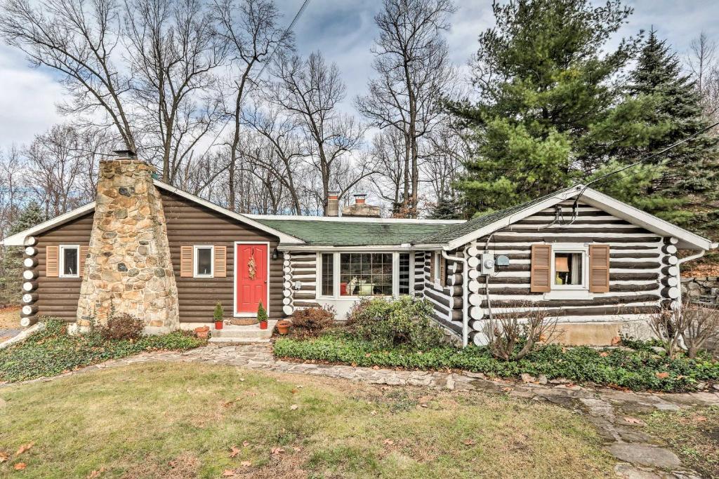 une cabane en rondins avec une porte rouge dans l'établissement Macungie Cabin with Fireplace Near Bear Creek Skiing, à Macungie