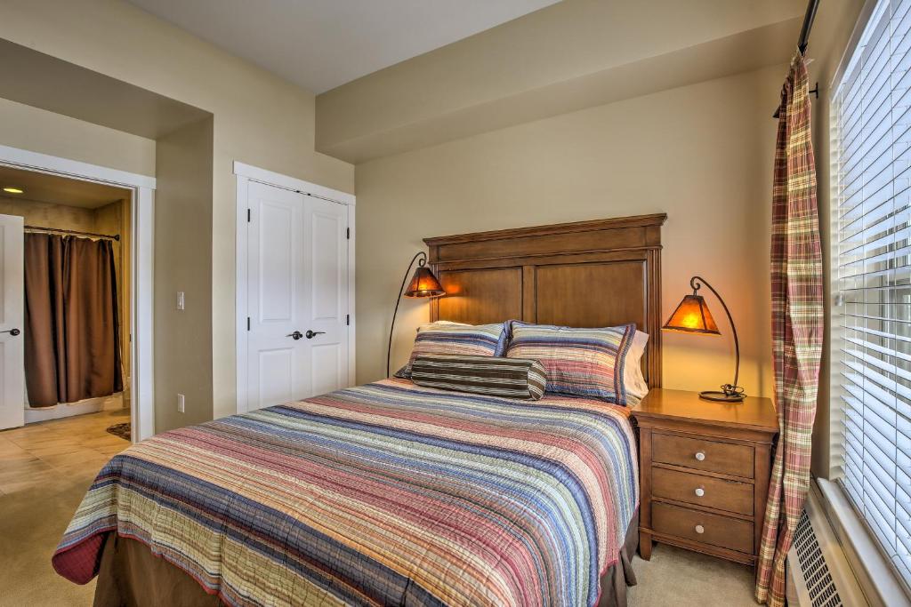 格蘭比的住宿－Base Camp One Resort Escape Steps From Ski Lifts!，一间卧室配有一张带木制床头板的床和两盏灯。