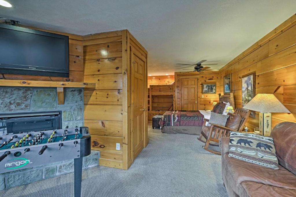 a living room with a fireplace and a flat screen tv at Pigeon Forge Resort Studio Cabin on Dollywood Ln! in Pigeon Forge