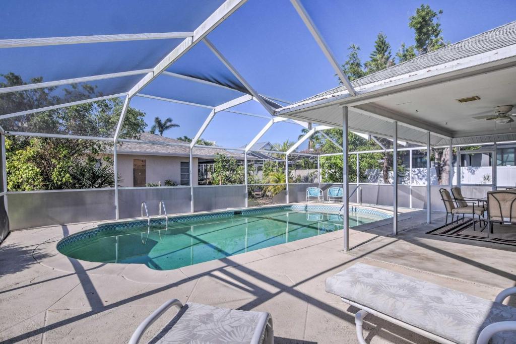 uma piscina numa casa com um grande tecto de vidro em Breezy Marco Island Home with Pool - Walk to Beach! em Marco Island