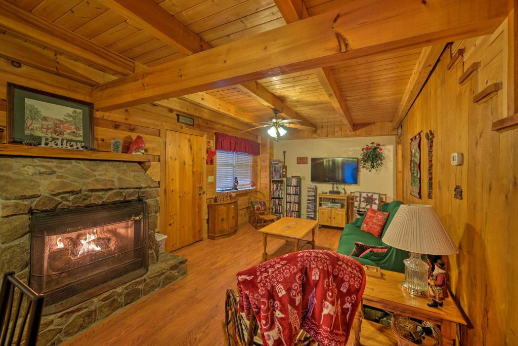 a living room with a fireplace in a cabin at Cozy Tellico Plains Cabin with Large Mountain Creek! in Tellico Plains