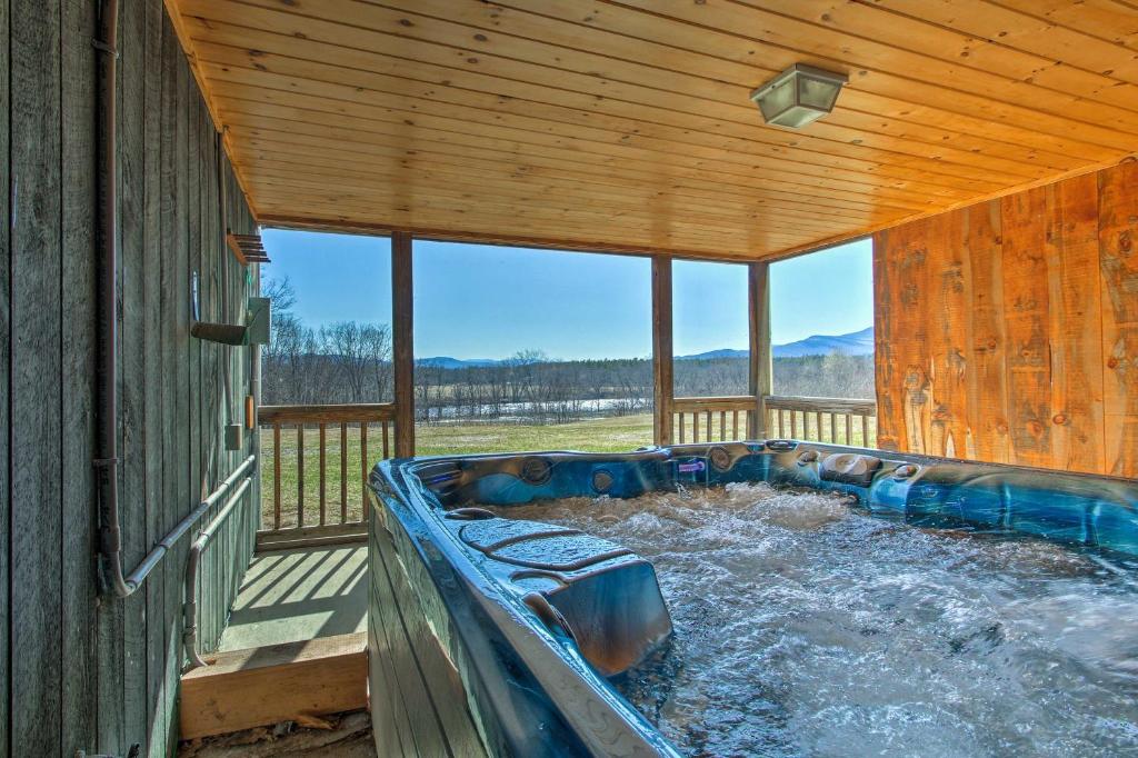 een hot tub op het dek van een hut bij Quiet Family Getaway Bethel Home with River Access! in Bethel