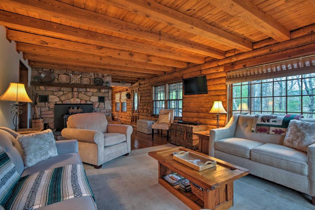 a living room filled with furniture and a stone fireplace at Family-Friendly Massanutten Log Home with Views! in McGaheysville