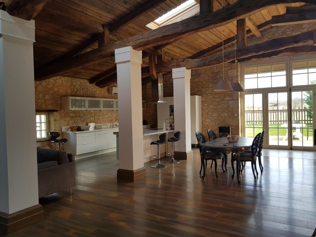 eine Küche und ein Esszimmer mit einem Tisch und Stühlen in der Unterkunft Villa Renaissance in Flaujagues