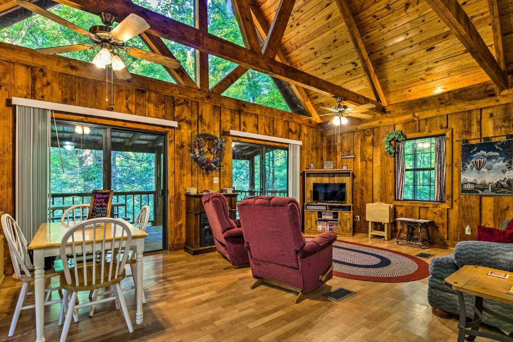 a living room with wooden walls and a ceiling with windows at Tellico Plains Cabin - 25 Acres, Backyard Creek! in Tellico Plains