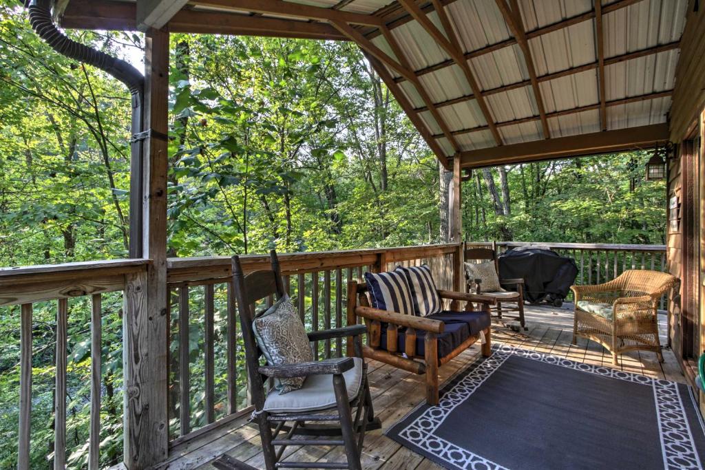 a screened in porch with chairs and a table at Gatlinburg Home with Hot Tub about 4 Mi to Town! in Gatlinburg