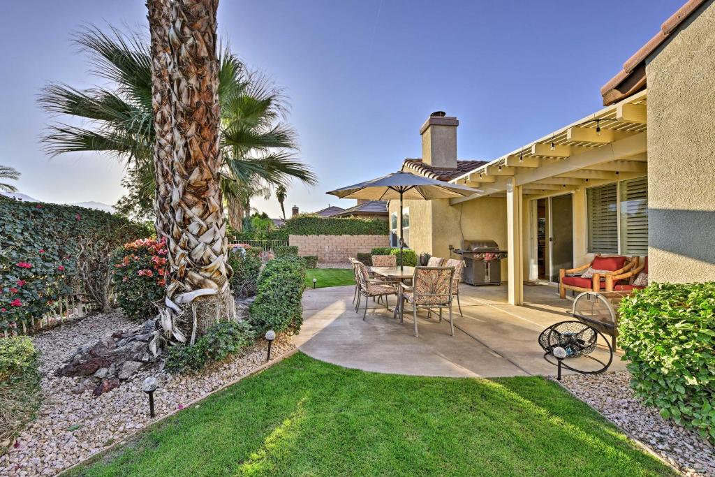 a patio with a palm tree and a table and chairs at Spacious Golf Home with Yard at Indian Palms Resort! in Indio