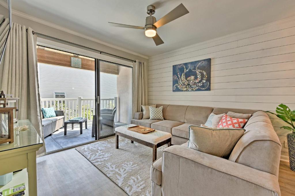 a living room with a couch and a ceiling fan at St Simons Island Condo with Pool Near Beach, Village in East End
