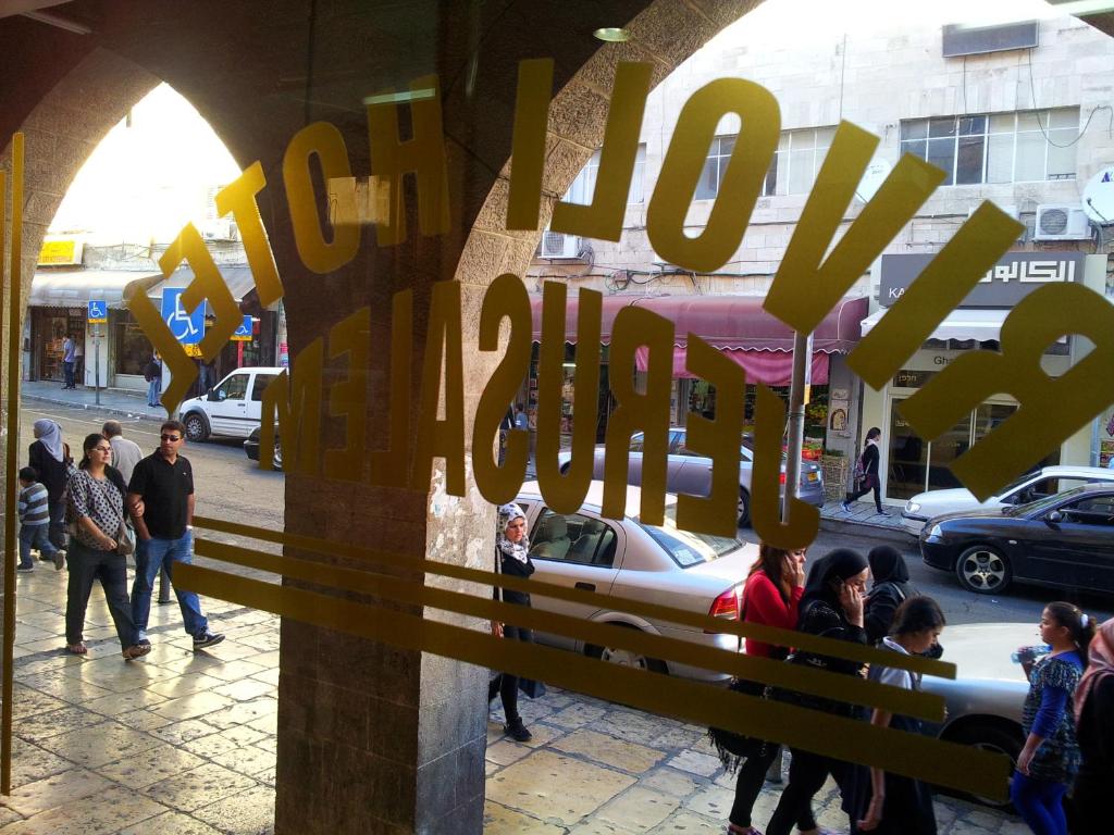 un grupo de personas caminando por una calle de la ciudad en Rivoli Hotel Jerusalem en Jerusalem