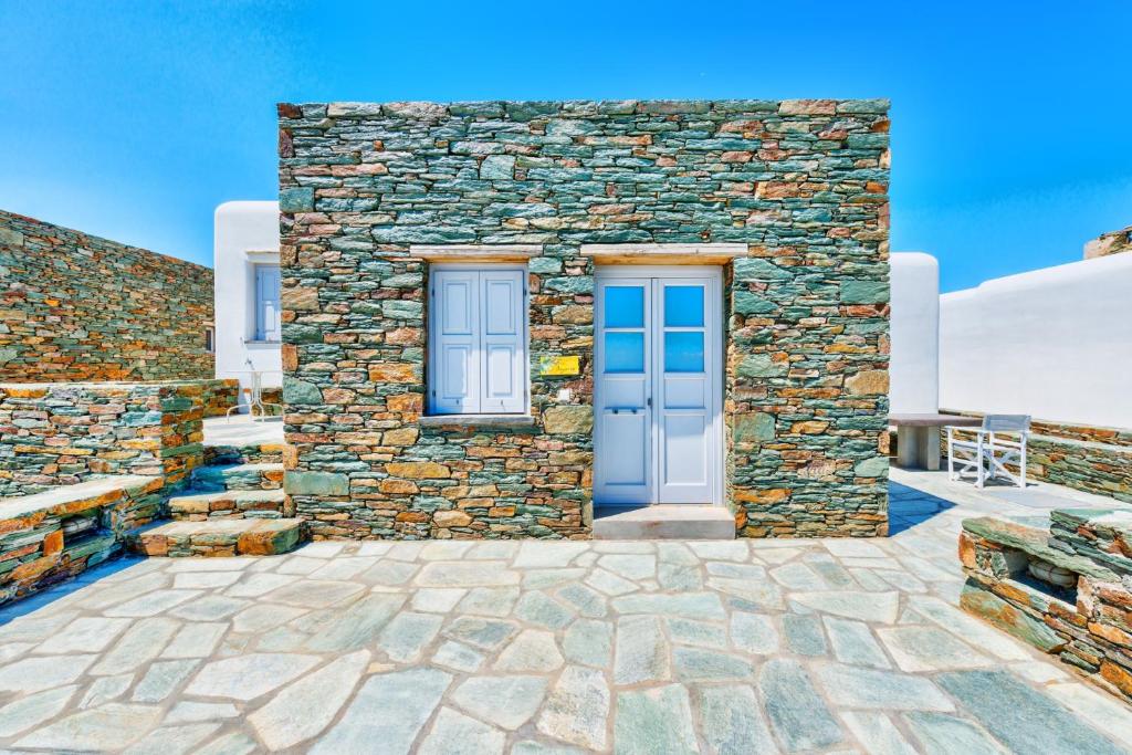 une maison en pierre avec une porte bleue dans l'établissement Alitanes, à Áno Meriá