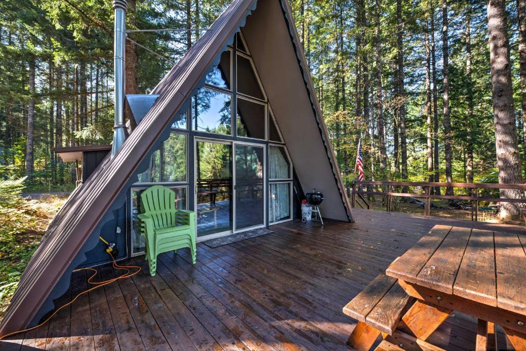- une vue sur le pont d'une cabine avec un fauteuil vert dans l'établissement Serene Washington Escape with Deck and Mountain Views!, à Packwood