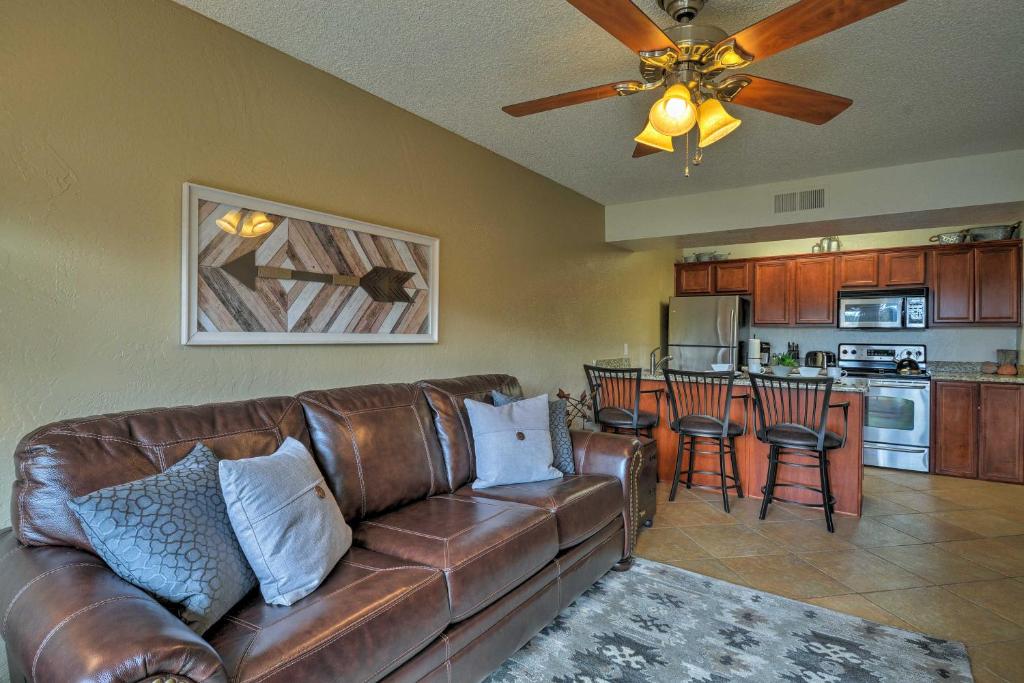 a living room with a brown leather couch and a kitchen at South Sedona Condo with Pool Access - Walk to Shops! in Sedona