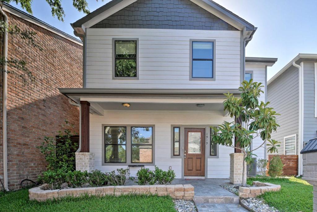 a white house with a brown door at Updated Home 15 Mins to the Galleria and Uptown! in Houston
