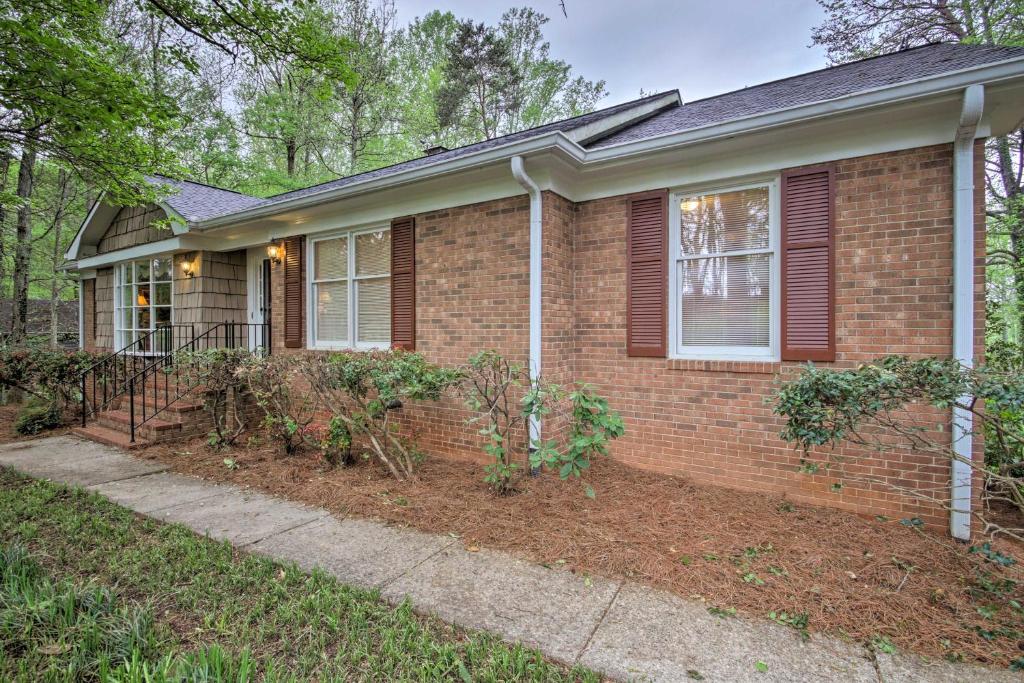 a home with a brick house with a porch at Spacious Family Home - 17 Miles to Winston-Salem! in Lewisville