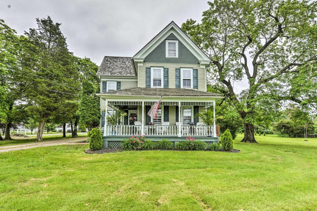 una casa verde con porche blanco y patio en Pet-Friendly Williamstown Farmhouse by Main Street, en Williamstown