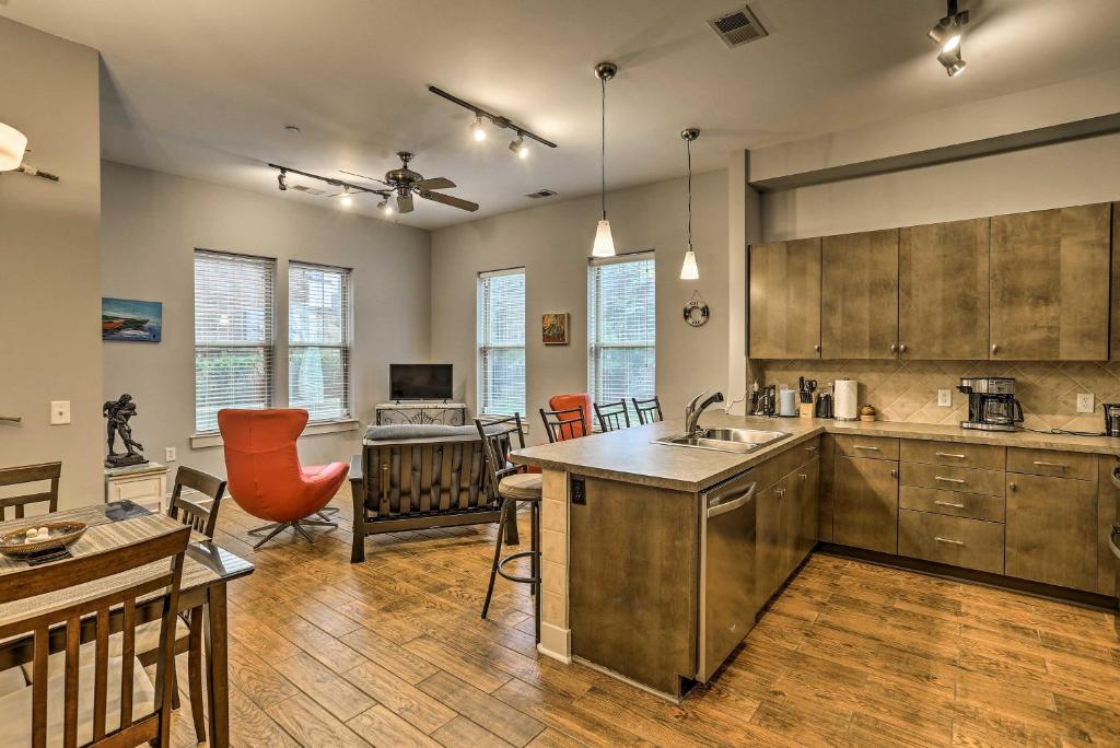 a kitchen with wooden cabinets and a dining room at Chic Wilmington Condo in Brooklyn Arts District! in Wilmington