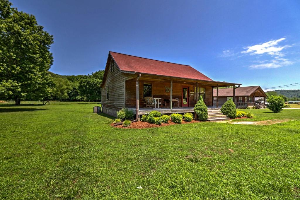 a house with a red roof on a green field at Dream Valley Mountain View Cabin with Covered Porch! in Mountain View