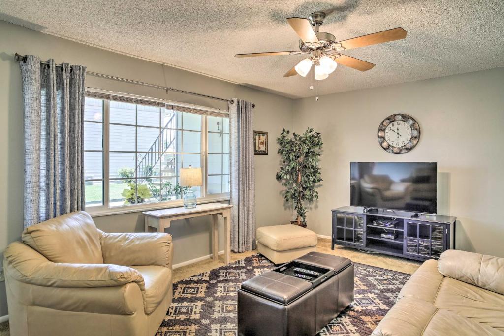 Kissimmee Condo with Lanai 10 Mi to Disney World! في كيسيمي: غرفة معيشة مع أريكة وتلفزيون بشاشة مسطحة