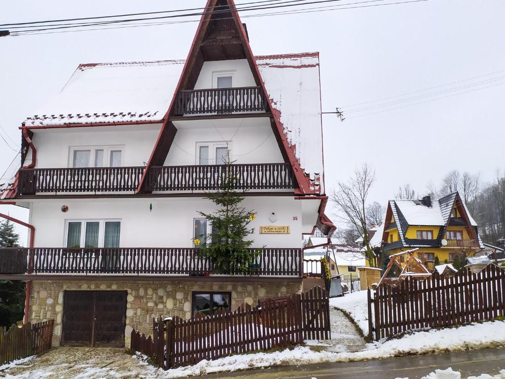 una gran casa blanca con techo rojo en Apartament u Helenki, en Groń