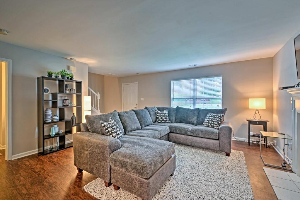 sala de estar con sofá azul y silla en Updated Charlotte Home with Central AandC - Near UNCC, en Charlotte