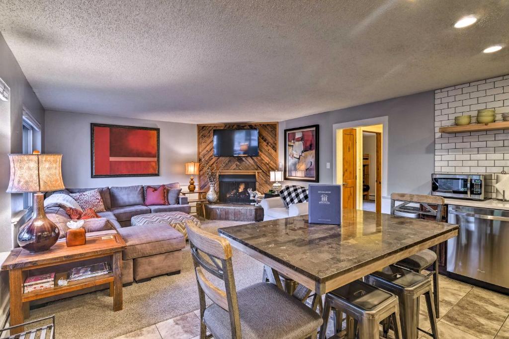 uma sala de estar com uma mesa e um sofá em Downtown Breck Condo on Main St - Walk to Slopes em Breckenridge
