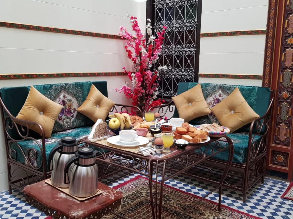 Dar Atlantic في فاس: غرفة بها أريكة وطاولة عليها طعام