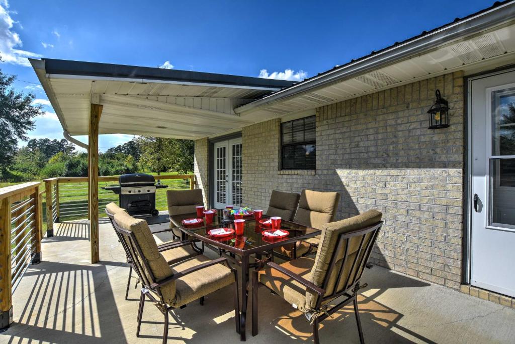 een patio met een tafel en stoelen en een grill bij Cozy Kirby Getaway with Patio, Near Lake Greeson! in Kirby