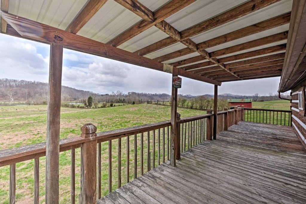 a porch of a cabin with a view of a field at Rogersville Barn Apartment on 27 Acres with Pond! in Rogersville
