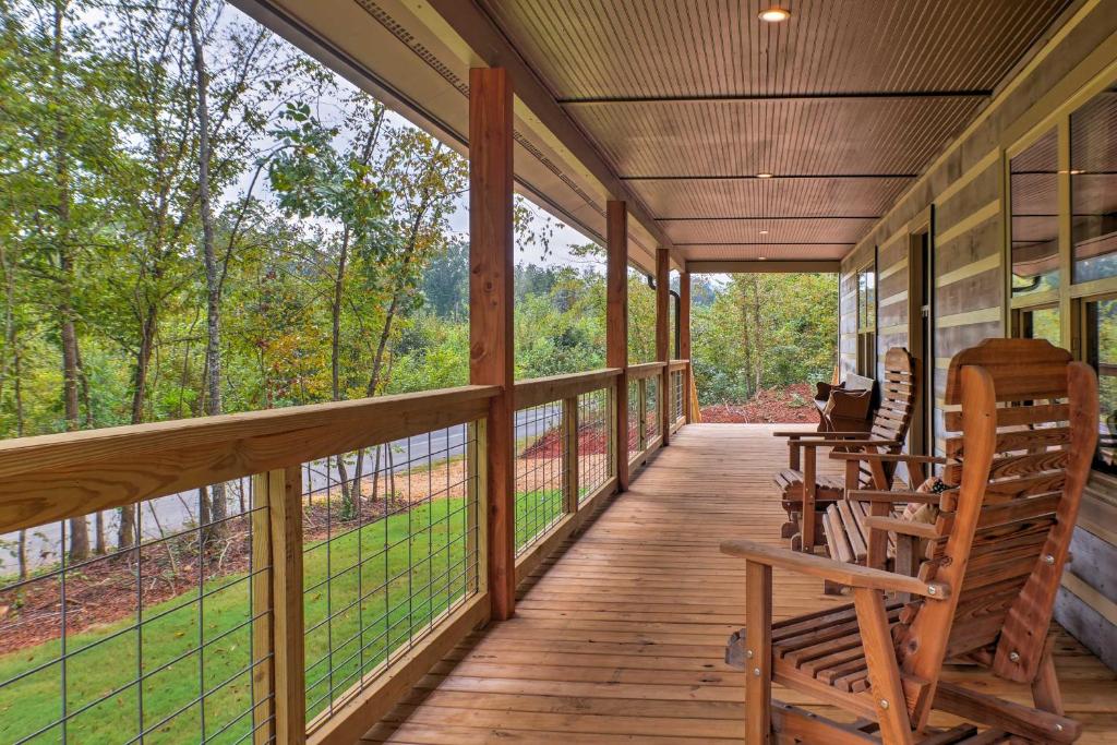 a porch with rocking chairs and a view of the woods at Summerville Getaway with Deck and On-Site Creek! in Summerville