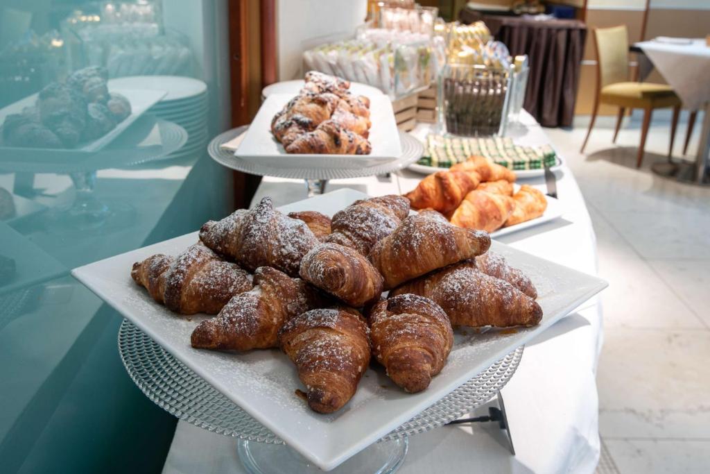 a tray of donuts and pastries on a table at Hotel Cappello D'Oro, BW Signature Collection in Bergamo