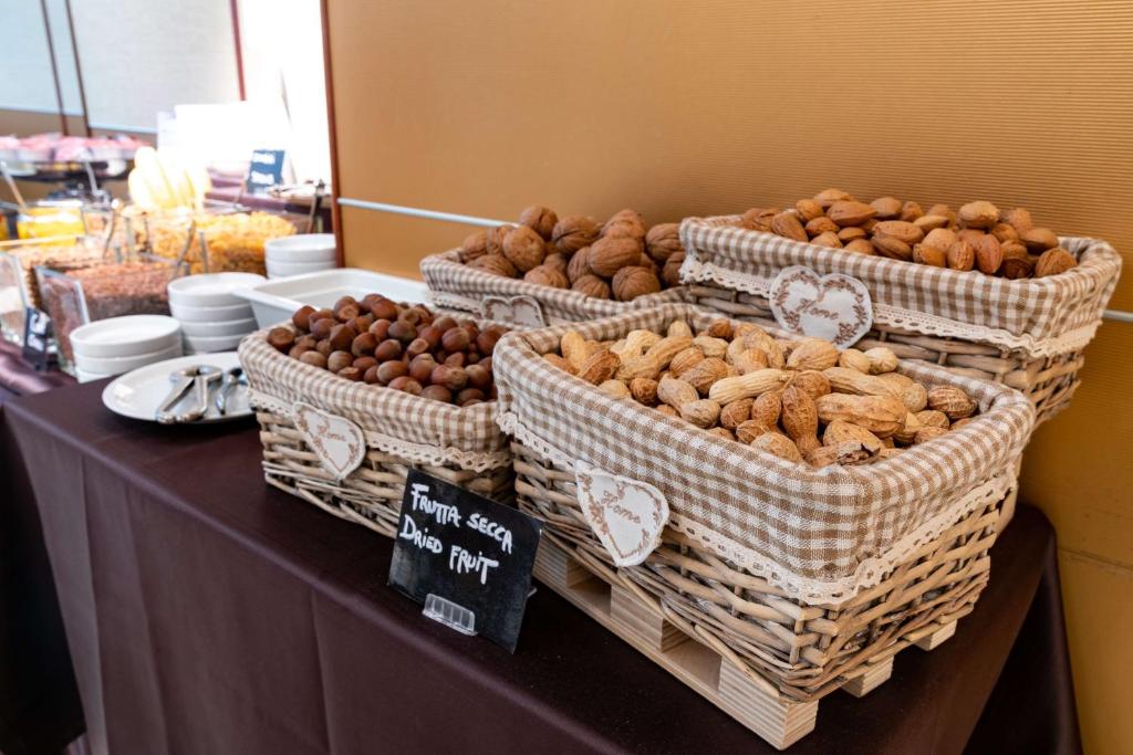 a table with baskets of different types of food at Hotel Cappello D'Oro, BW Signature Collection in Bergamo