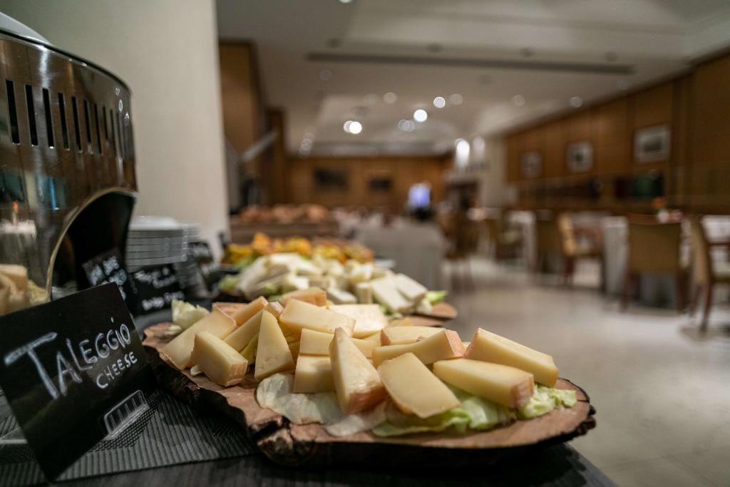 a plate of cheese and sandwiches on a table at Hotel Cappello D'Oro, BW Signature Collection in Bergamo