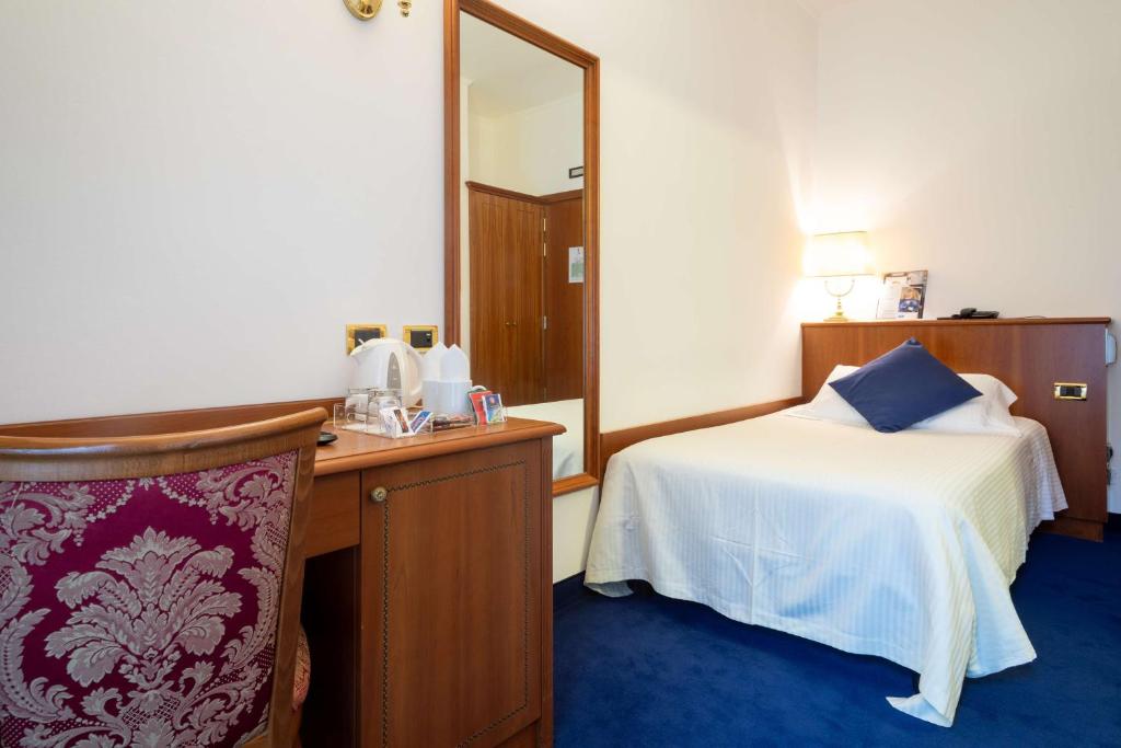a hotel room with a bed and a mirror at Hotel Cappello D'Oro, BW Signature Collection in Bergamo