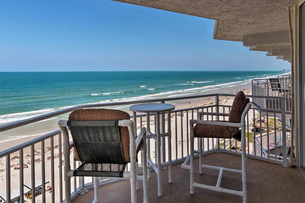 a balcony with two chairs and a table and the beach at Waterfront Daytona Beach Shores Condo with Amenities in Daytona Beach Shores